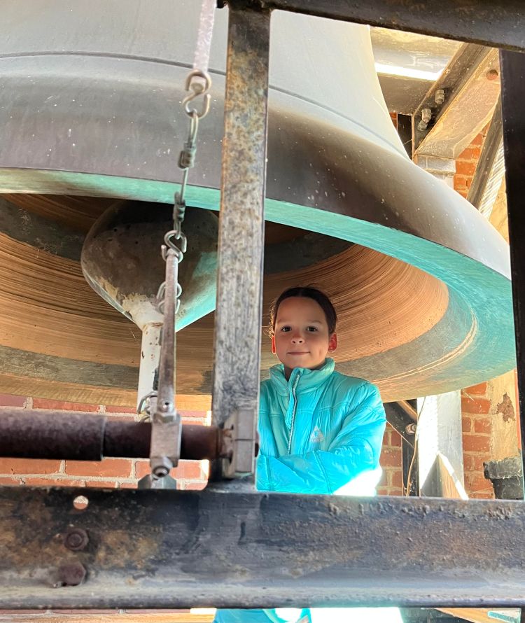 boy under a carillon bell